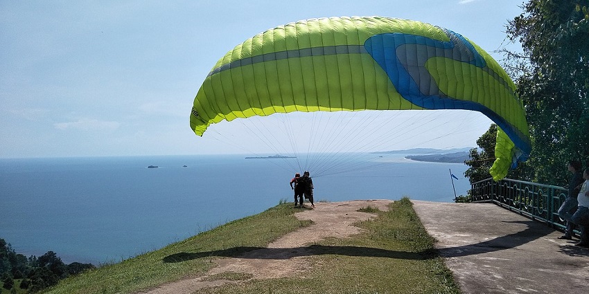 A paraglider getting ready to jump off the edge to enjoy adventure sports in Bali