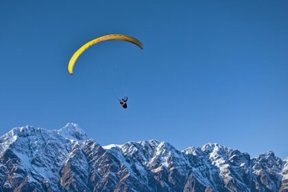 A glimpse of a person gliding high up in the clear skies and soaking panoramic vistas.