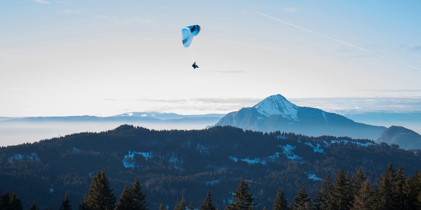 Paragliding bird's-eye view of lush greenery and sprawling forest below in Bhaderwah