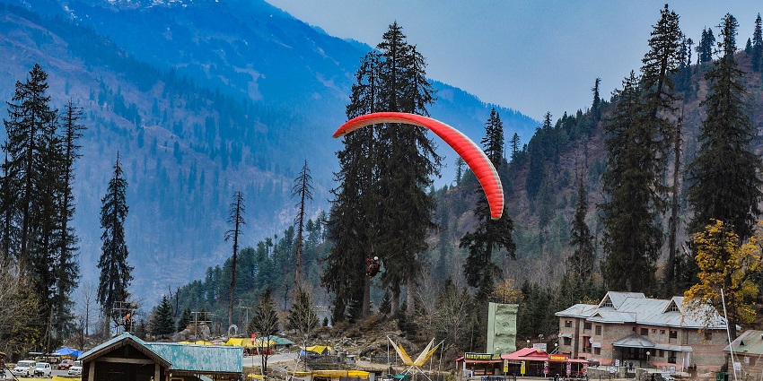 Colourful paragliders soaring over the scenic Solang Valley in Manali, India.