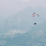 paragliding over the mountains and green meadows in jammu - explore best paragliding in Jammu