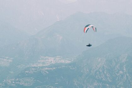 paragliding over the mountains and green meadows in jammu - explore best paragliding in Jammu