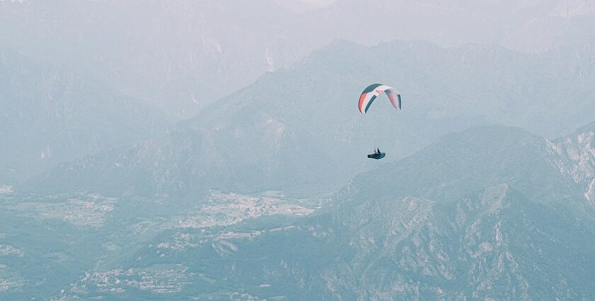 paragliding over the mountains and green meadows in jammu - explore best paragliding in Jammu