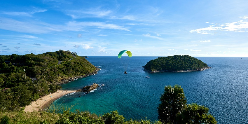A mesmerising view of a person parasailing at Windmill Viewpoint in Phuket, Thailand.