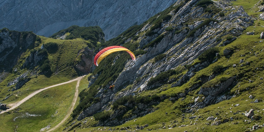 A picture of a parasailer taken from a height showing pretty landscapes