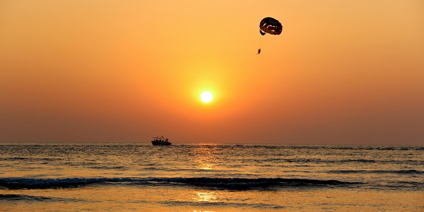 Long-angle silhouette of a paraglider, adding to the variety of water sports in Vietnam.
