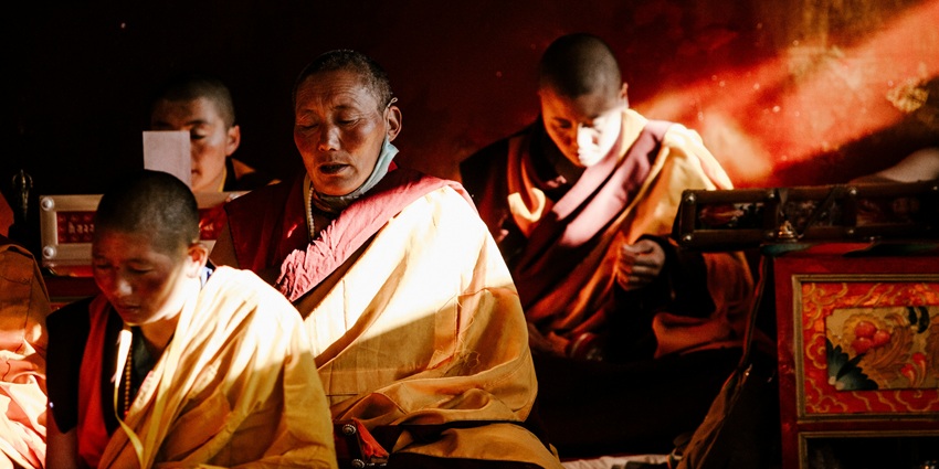 An Image of two Buddhist monks meditating in a serene and open-air setting