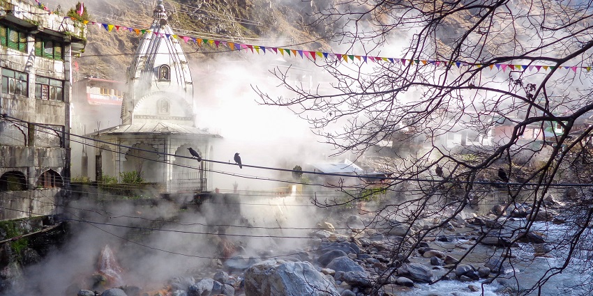 A stunning view of the Parvati River running through Manikaran with a temple on the side.