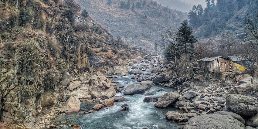 An aerial picture of a valley in Himachal with a tiny river flowing through the rocks