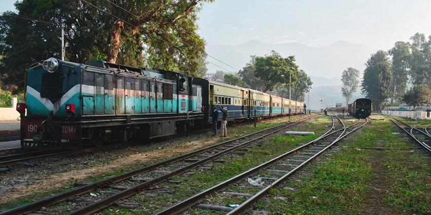 Snowy mountains surrounded by lush greenery a passenger train - Hill Stations Near Palampur.