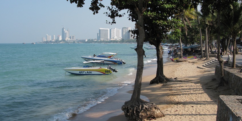 Vibrant Pattaya Beach with golden sand, bustling shoreline, and sparkling blue waters.