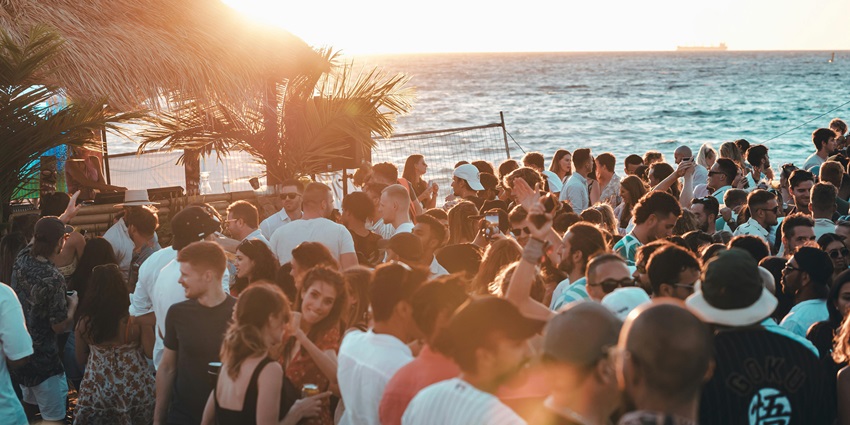 An aerial picture of a beach party with people enjoying drinks and the open-air ambience