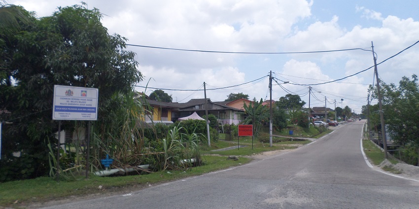 Traditional Malay village with colourful houses and lush greenery.