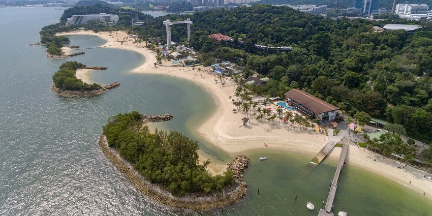 Tourists sit and relax at this beach while enjoying the natural beauty.