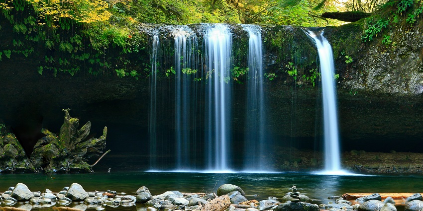 A glimpse of shimmering waters cascading down and merging with the flowing river.