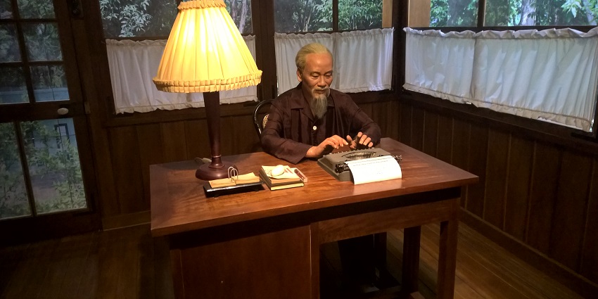 A wax statue of the president using a wax typewriter at the Ho Chi Minh Museum.