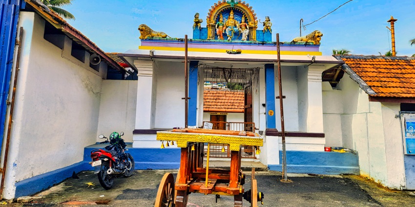 A frontal view of a temple entrance in Trivandrum with idols of deities over the gate