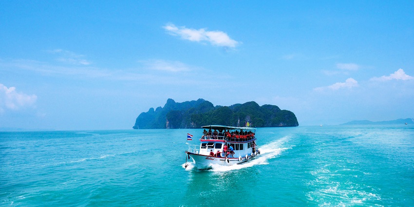 A mesmerising view of a boat running over a water body at Phang-nga Bay in Thailand.
