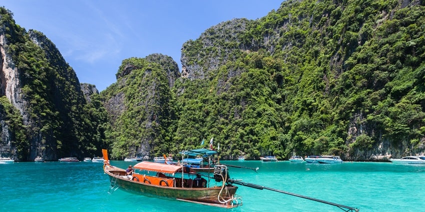 A view of a boat sailing on the turquoise-blue waters of the picturesque Phi Phi Islands.
