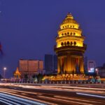 A breathtaking view of a city with a monument covered in yellow lights during the night.