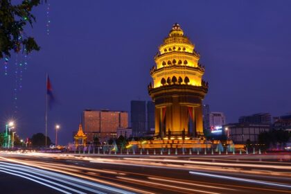 A breathtaking view of a city with a monument covered in yellow lights during the night.