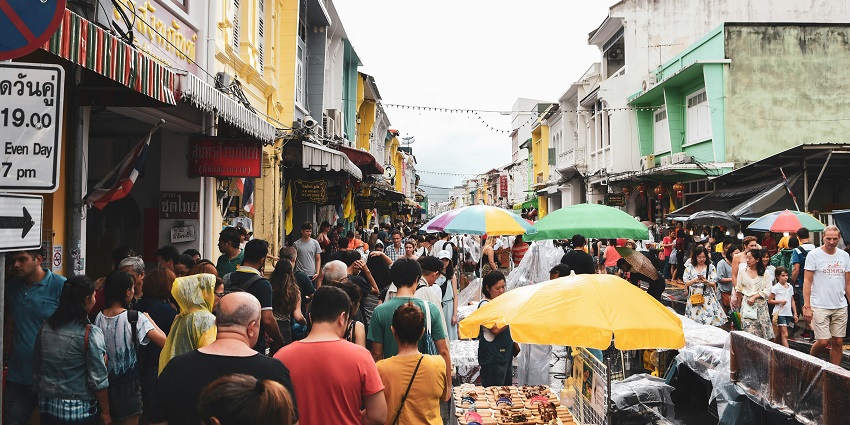 A picture of several people exploring the bustling marketplace in Phuket, Thailand.