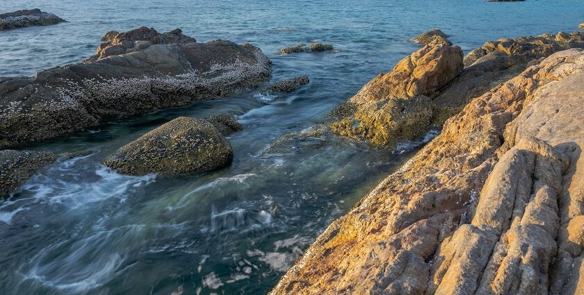 A scenic view of a the famous Freedom Beach with rocks and trees in the surroundings.