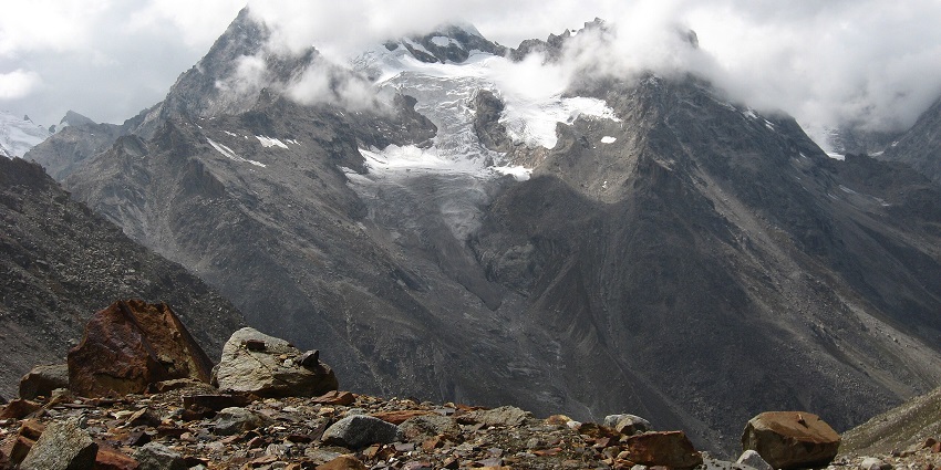A mesmerising view of the Parvati Mountain covered in snow and surrounded by clouds.