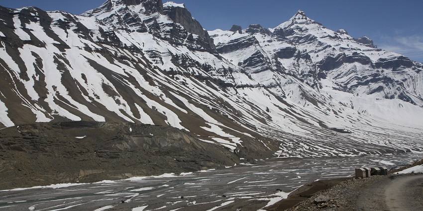Partially frozen river situated at the foot hills of the majestic snow capped mountains