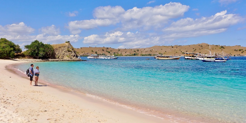 Pink Beach on Komodo Island has small red coral fragments with blue seas & marine life