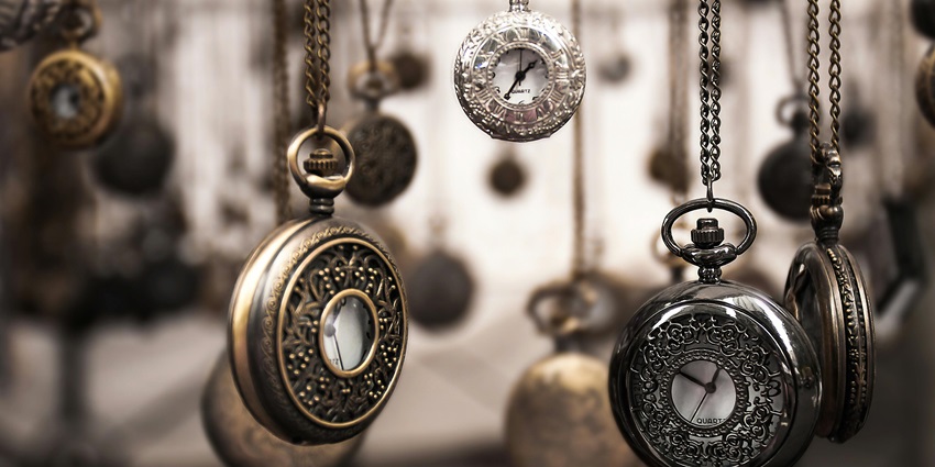 Collection of silver pocket watches with intricate details, arranged with selective focus.