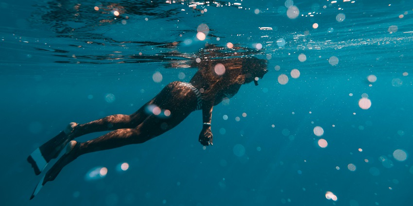 A picture of a woman taken from underwater while enjoying snorkelling