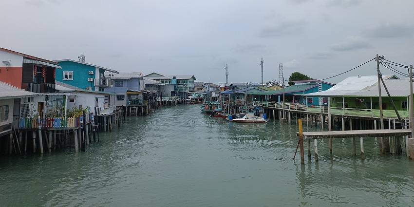 A picture of a residential settlement around a canal with boats parked at a corner