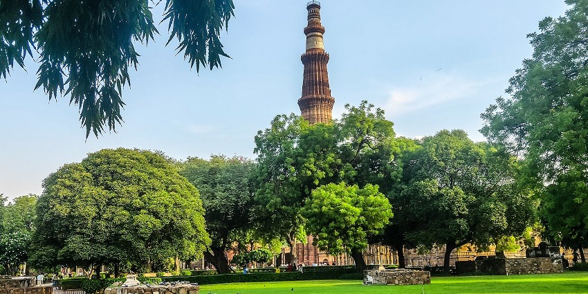 Beautiful panoramic snap of the Qutub Minar surrounded by the gardens and trees in Delhi