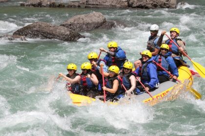 A descriptive image of people rafting amidst crystal-clear waters and enjoying themselves.