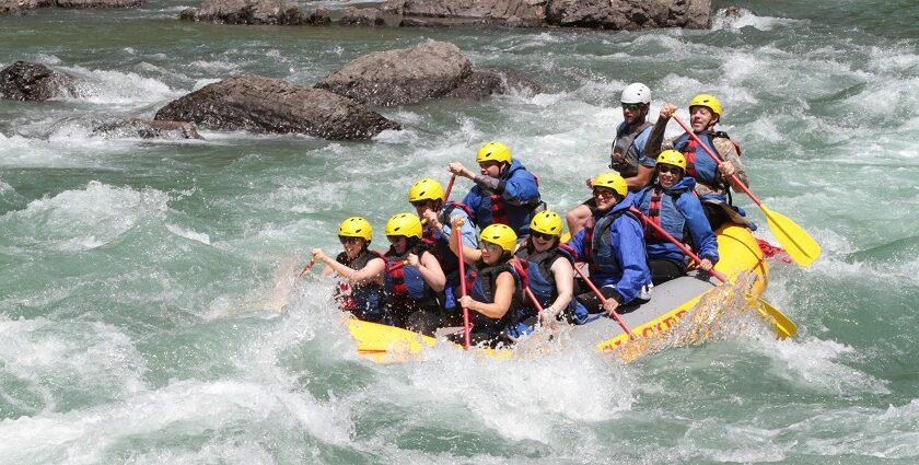 A descriptive image of people rafting amidst crystal-clear waters and enjoying themselves.