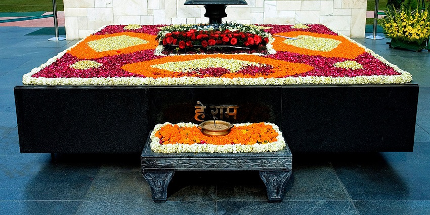 An elevated platform covered with flowers in front of an immortal flame