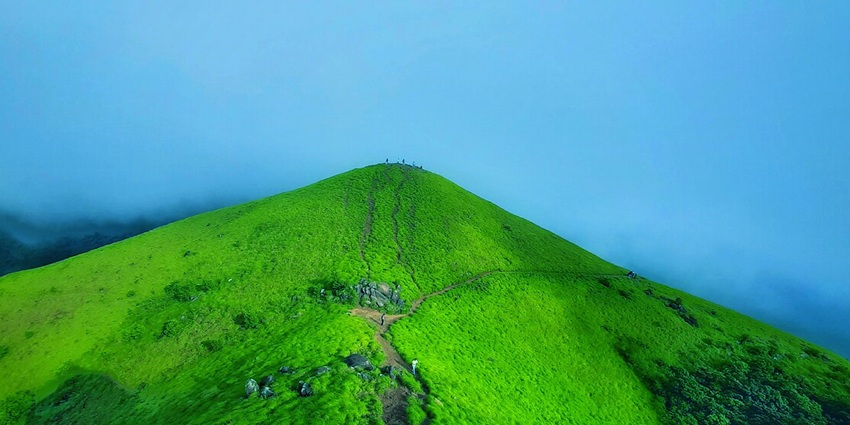 Ranipuram peak crowned by clouds, atop Kerala’s tranquil grass‑clad hills