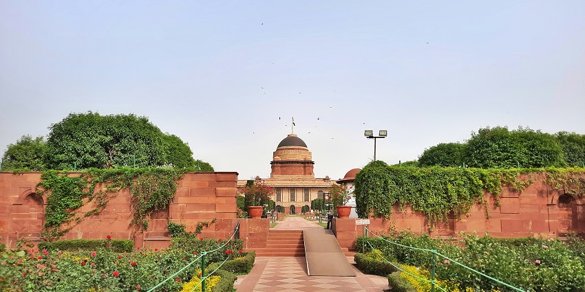 A fascinating view of Rashtrapati Bhavan surrounded by greenery during the daytime.