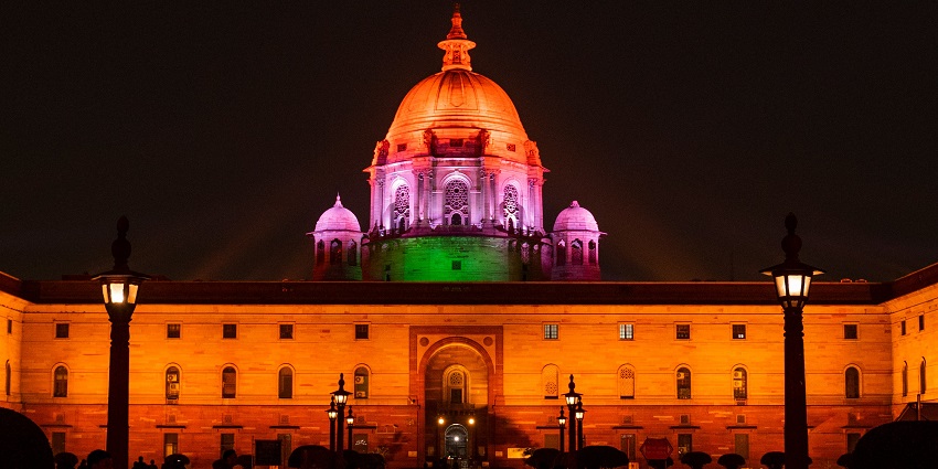 Tourists exploring the iconic Rashtrapati Bhawan in Delhi, India, with its grand sandstone facade.
