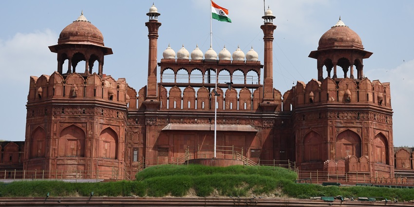 Red Fort domes with Indian flag against clear sky–places to visit near humayun tomb