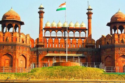 A frontal view of the Red Fort in Delhi with a garden in front