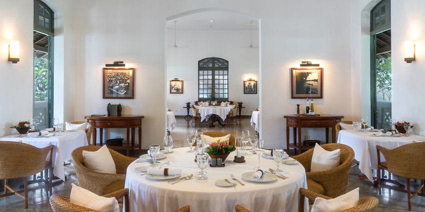 Beautiful picture of a hotel with a round table in the centre and brown chairs around it.