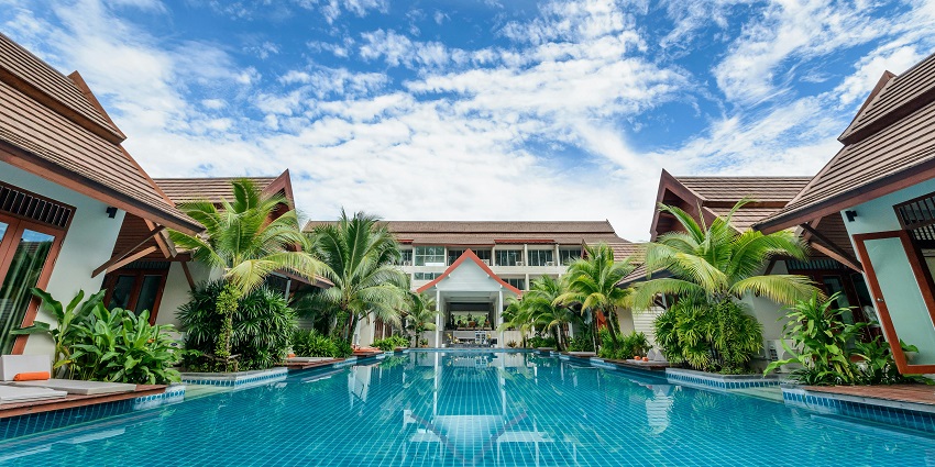 Water reflecting nearby buildings under a clear blue sky, creating a peaceful environment.