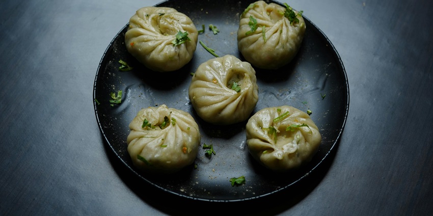 Mounth watering image of the dunplings or Momo, served in the black ceramic plate