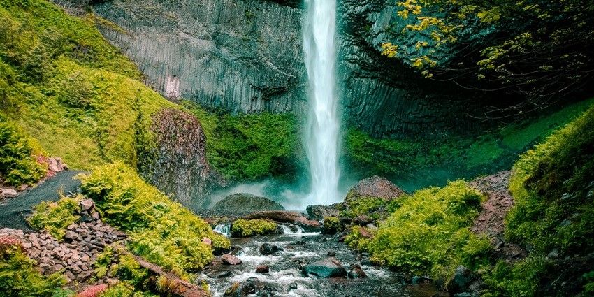 A breathtaking view of the cascading waters of Rimbi Waterfalls surrounded by greenery.