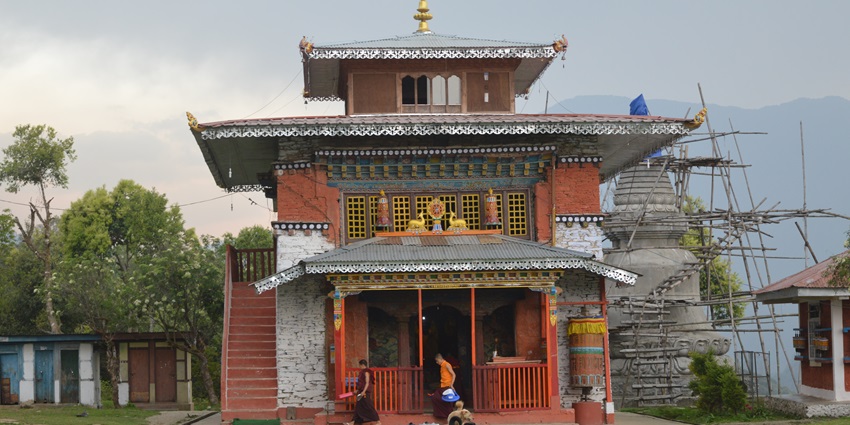 A view of rustic hued Rinchenpong Monastery nestled amidst the lush green peaks.
