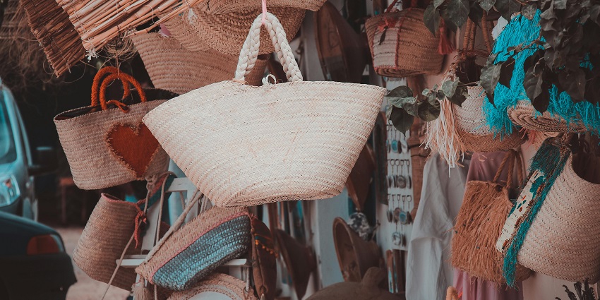 A mesmerising view of a lot of hand bags hanging in a shopping mall for display.