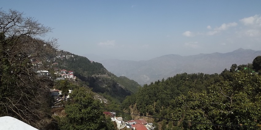 Panoramic view of Rishikesh with Ganges River and suspension bridge.