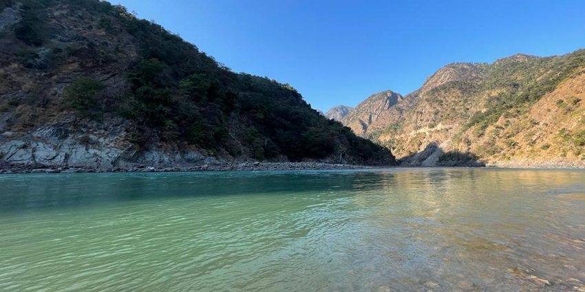 A picture of the scenic river Ganges flowing through the spiritual city of Rishikesh